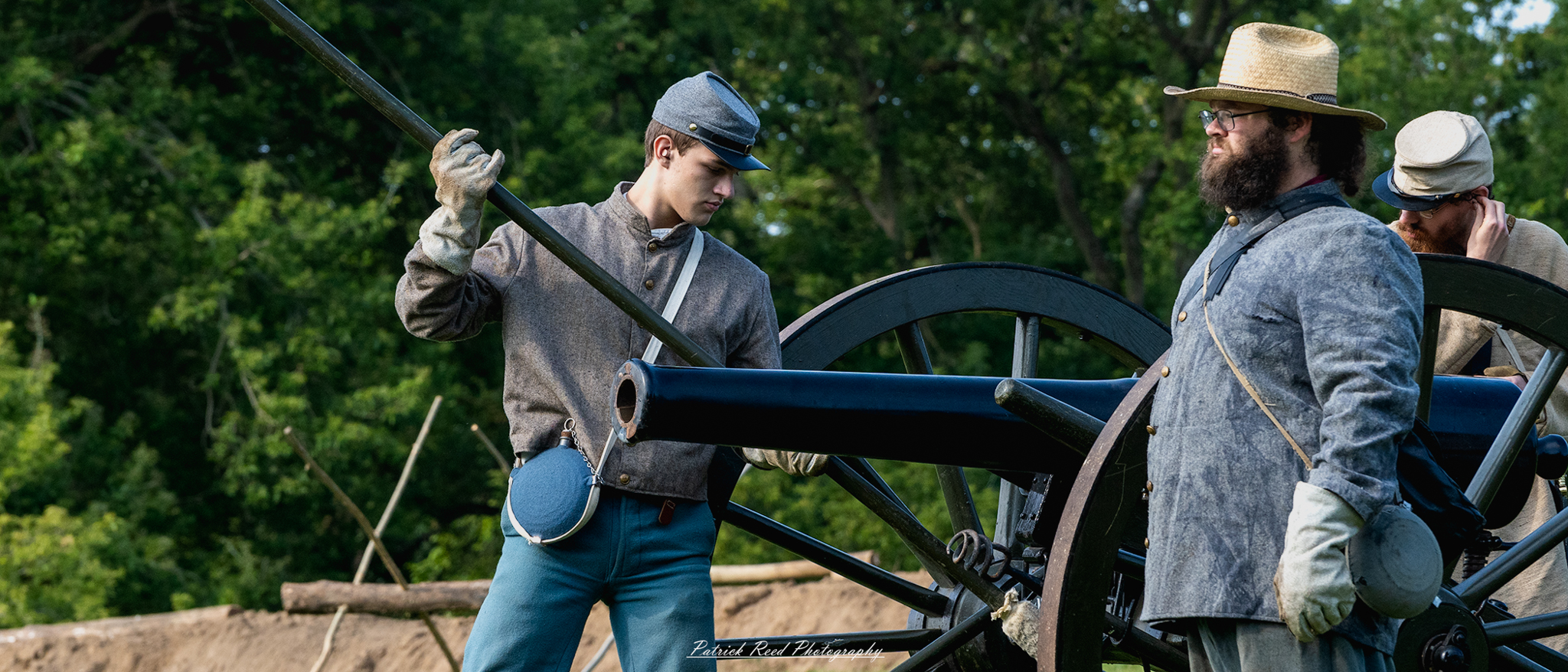 A Confederate soldier preparing a cannon to fire, dressed in a gray uniform as he carefully loads the cannon with ammunition. His expression is focused and determined, surrounded by fellow soldiers who assist in the operation, highlighting the urgency and intensity of the moment on the battlefield.